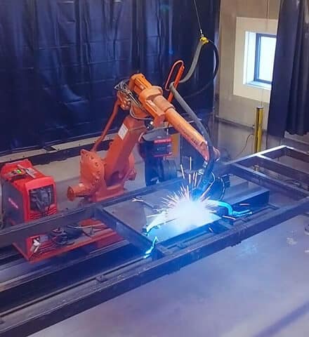 Oranger Schweißroboter von ABB beim Schweißen bei NMF Industries nach der Aufrüstung